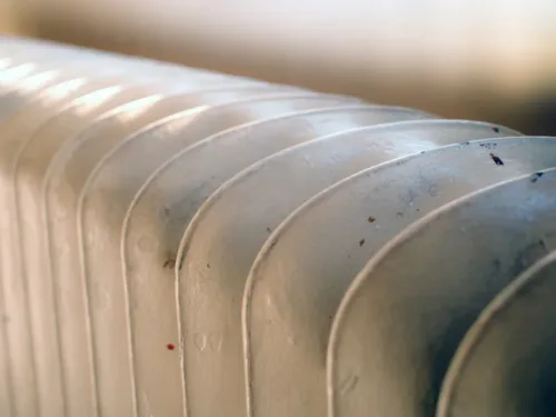 A close-up of a white, finned radiator.